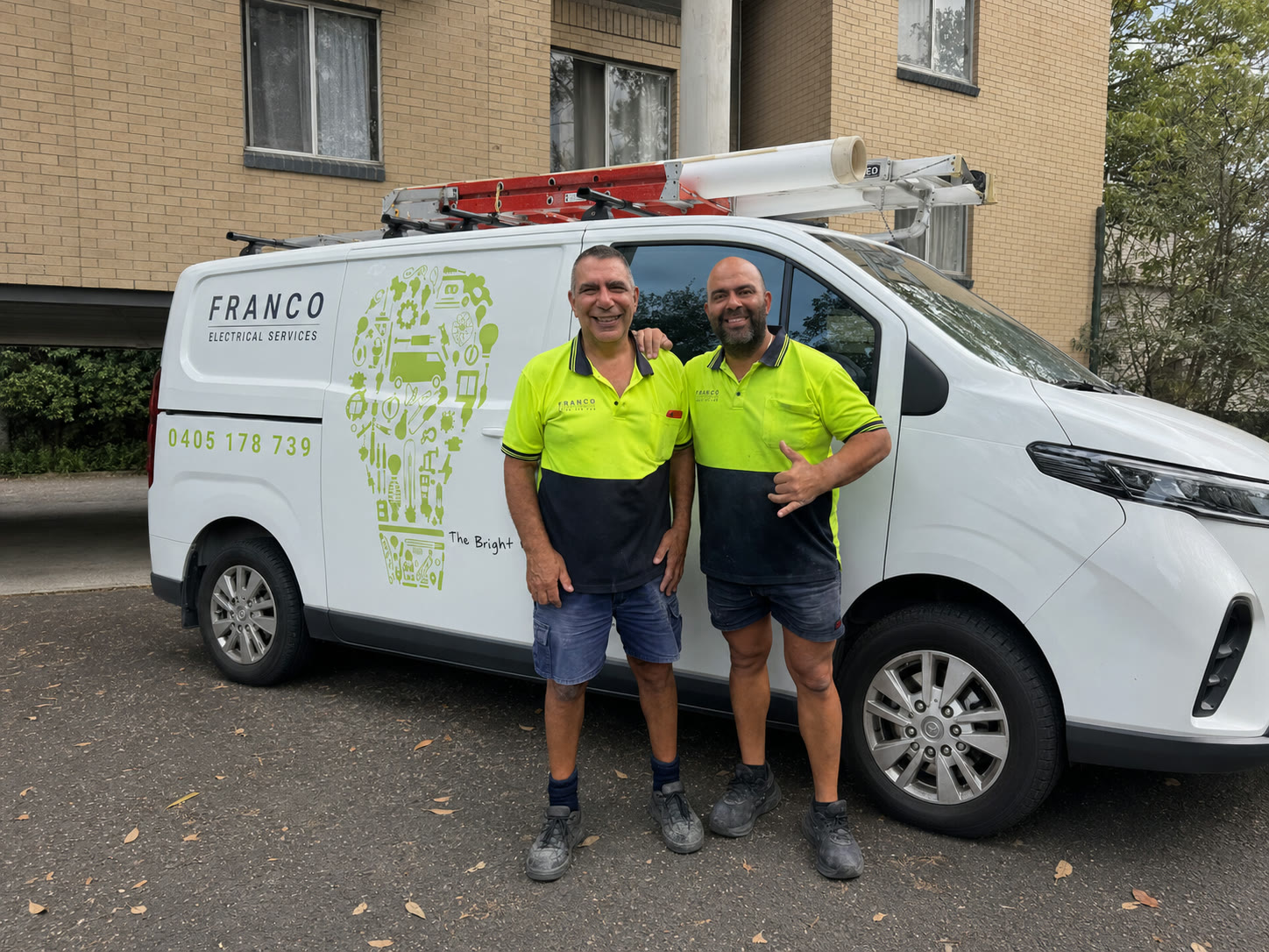 Franco Electrical Services electricians beside their signwritten van on a Sydney street